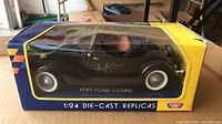 Side view of black 1949 Ford Coupe die-cast model showing Humphrey Bogart's signature and the packaging box.