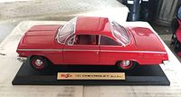 Front and side view of red 1962 Chevrolet BelAir model car on display stand