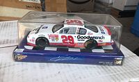 Side view of 1:24 scale White #29 Goodwrench Kevin Harvick car in clear plastic display case, sitting on blue base with Winner's Circle branding.