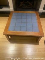 Overhead view of square oak frame coffee table with blue tiled tabletop