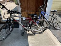 Two mountain bikes outside a shed door, one Trek and one Diamondback with deflated tires