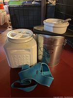 Photo showing all items in the lot including two food storage containers, ceramic dog bowl with spoon, and dog harness.