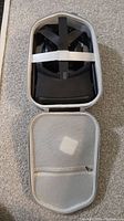 Top view of open zippered carrying case with Oculus Quest headset inside secured by elastic bands.