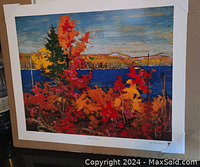Photo of Tom Thomson Autumn Foliage print on white bordered mount, showing colorful autumn leaves, blue lake, hills and sky.