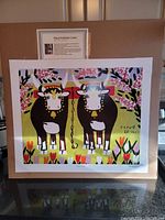 Full view of colorful lithograph print of two oxen in a spring flower scene with trees and signature by Maud Lewis.