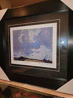 Front angle view of professionally framed fine art print 'Cloudy Sky' by JEH MacDonald showing detailed brushwork, black frame, and white inner matting.