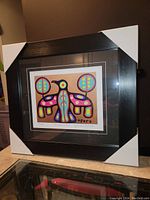 Front angled view of the professionally framed fine art print titled Thunderbird Spirit by Christian Morrisseau showing the full artwork with protective corner covers on the frame.
