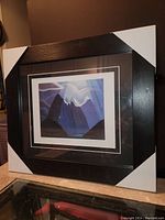 Full view of the framed Lawren Harris print with white corner protectors visible on the black frame.