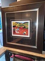 Photo showing the entire framed artwork from an angle revealing the frame style and print placement.