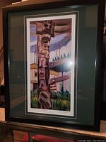 Framed print of Totem by Emily Carr showing the totem pole and background scenery with signature and title visible.