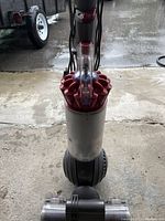 Front view of vacuum showing cyclone assembly, dust canister, ball base