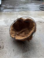 Close-up photo of one black metal hanging basket with brown coconut coir liner.