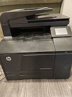 Front angled view of a black HP multifunction laser printer with touchscreen and automatic document feeder.