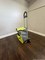 Full view of shopping cart with yellow and gray fabric bag and metal handle.