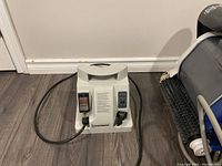 White Hayward power supply unit on wood floor showing GFCI switch and power cable