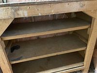 Wooden work bench showing the shelves and surface wear.