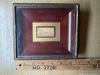Framed miniature painting, showing scale against a ruler.