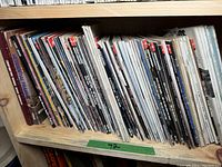 Shelf filled with assorted woodworking magazines showing the spines and some covers.