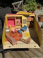 Full frontal view of the open Dream House interior showing furniture layout, printed interior walls with pictures, and various accessories.