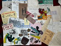 Wide view of various Boy Scout publications, badges, pins, fabric patches, letters, and photographs arranged on table.