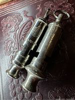 Two metal Boy Scout whistles, one with a keyring, showing front view with logos and inscriptions 'BOY SCOUT' and 'CANADA'.