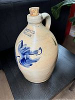 Front view showing maker's mark 'H. SCHULER PARIS.ONT' above cobalt blue abstract floral motif on beige salt-glazed stoneware.