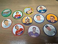 11 assorted Shirriff collectible coins featuring sports and other themes arranged on a wooden surface
