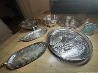 Overview of assorted silver plated items including trays, compote, flower bowl, cutlery, and small frame.