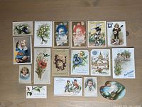 Overview of 18 Victorian-era trade cards with various floral, children, and scenic designs.