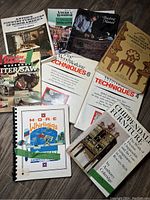 Top view of all 10 woodworking books displayed overlapping showing cover titles and artwork.