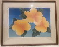 Full view of framed and matted print showing artwork with three yellow-orange hibiscus flowers on a blue background, wooden frame and cream matting.