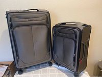 Pair of closed Samsonite suitcases, showing matching exterior design and front zippered pockets on each.