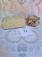 Two vintage musical trinket boxes side by side on fabric, showing size and general condition.