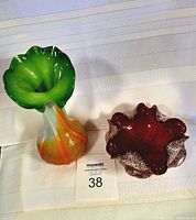 Top-down and side-angle photo of the two glass items on fabric background with auction card labeled 38