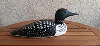 Side view of hand carved loon decoy showing detailed painting and shape.