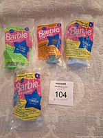 Four vintage McDonald's promotional Barbie mini dolls in original sealed packaging, showing front of the packages.