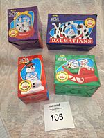 Four McDonald's 101 Dalmatians promotional toys in unopened boxes, arranged on carpet