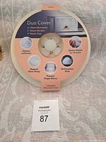 Front view of Duo Cover collapsible microwave cover packaging showing features like steam recipes, plastic free, dishwasher safe, magnet stow-away, prevents finger burns.
