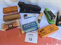 Overview of all vintage staplers and staples including green Arrow stapler and multiple staple boxes.