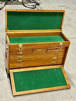 Chest open with top lid raised and drop-front panel lowered revealing green felt-lined top compartment and interior condition.