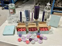 Overview of all items including boxed red votive candles, assorted tealight candles, purple pillar candle, silver candle holders with taper candles, and the decorative metal lantern. Also shows some original PartyLite packaging.