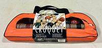 Orange zippered fabric carrying case with 'Croquet' label showing set name and contents, front view.