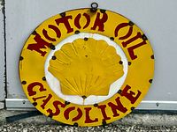 Front view of round metal Shell Motor Oil Gasoline wall plaque featuring yellow scallop logo and red text on yellow and white background.