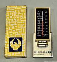 Top view of original box and vintage BP Canada table thermometer showing temperature display and stand base with branding.