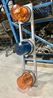 Front view of vintage emergency rooftop lighting system showing three mounted beacon lights on metal rack.