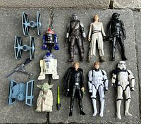 Full lot of Star Wars figures arranged on stone floor, showing all characters and two TIE fighter models.