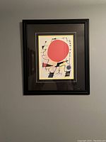 Full view of the framed La Soleil Rouge print on a gray wall.