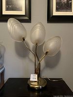Front view of vintage brass table lamp with frosted glass leaf-shaped shades