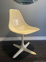 Front angled view of vintage Maurice Burke Tulip Chair, showing molded fiberglass seat and steel X base with wear.
