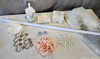 All items laid out: rod, ceramic pieces, curtain, hooks, suction cups